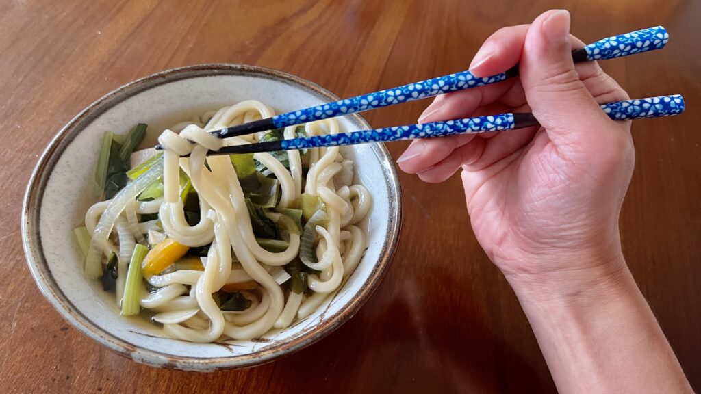 杵型多久島箸でうどんをつかんでいる写真